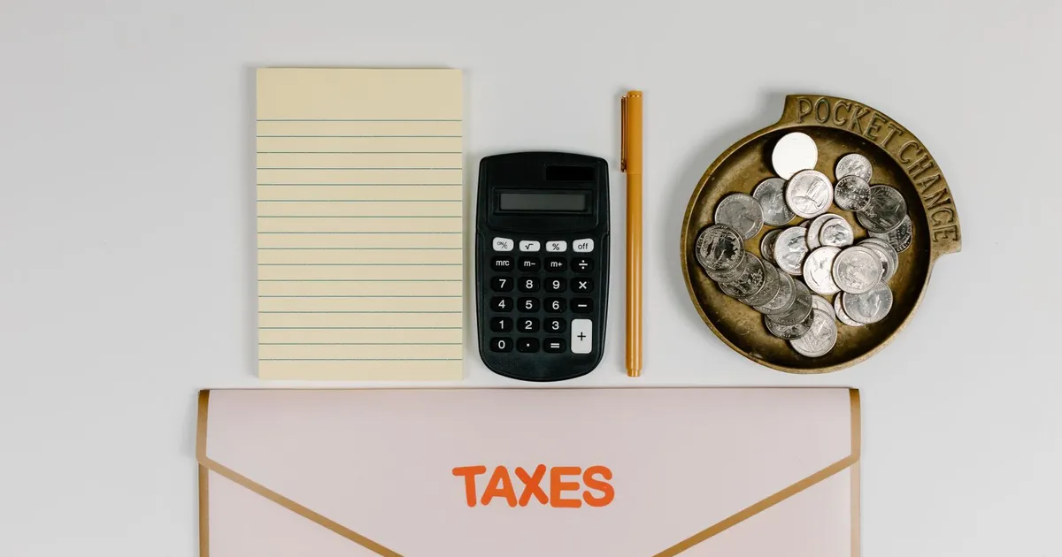 Calculadora, monedas y documentos sobre un escritorio