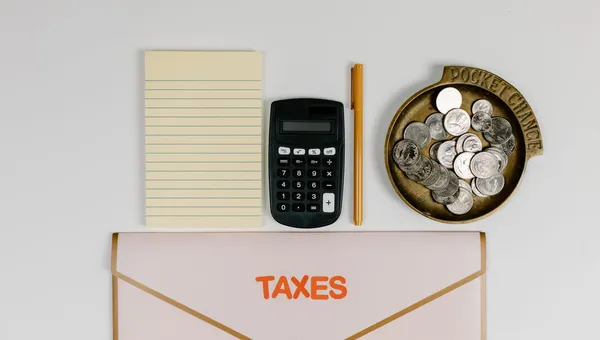 Calculadora, monedas y documentos sobre un escritorio