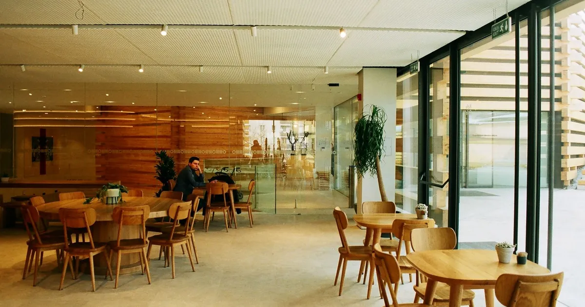 Comedor amplio con mesas de madera y ventanales